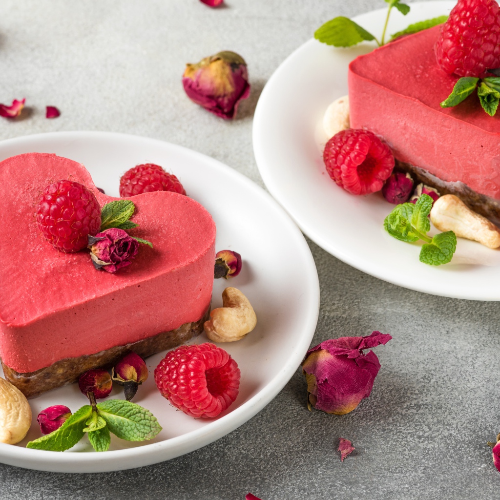 Фруктовое суфле в форме сердца на тарелке с малиной и орехами 