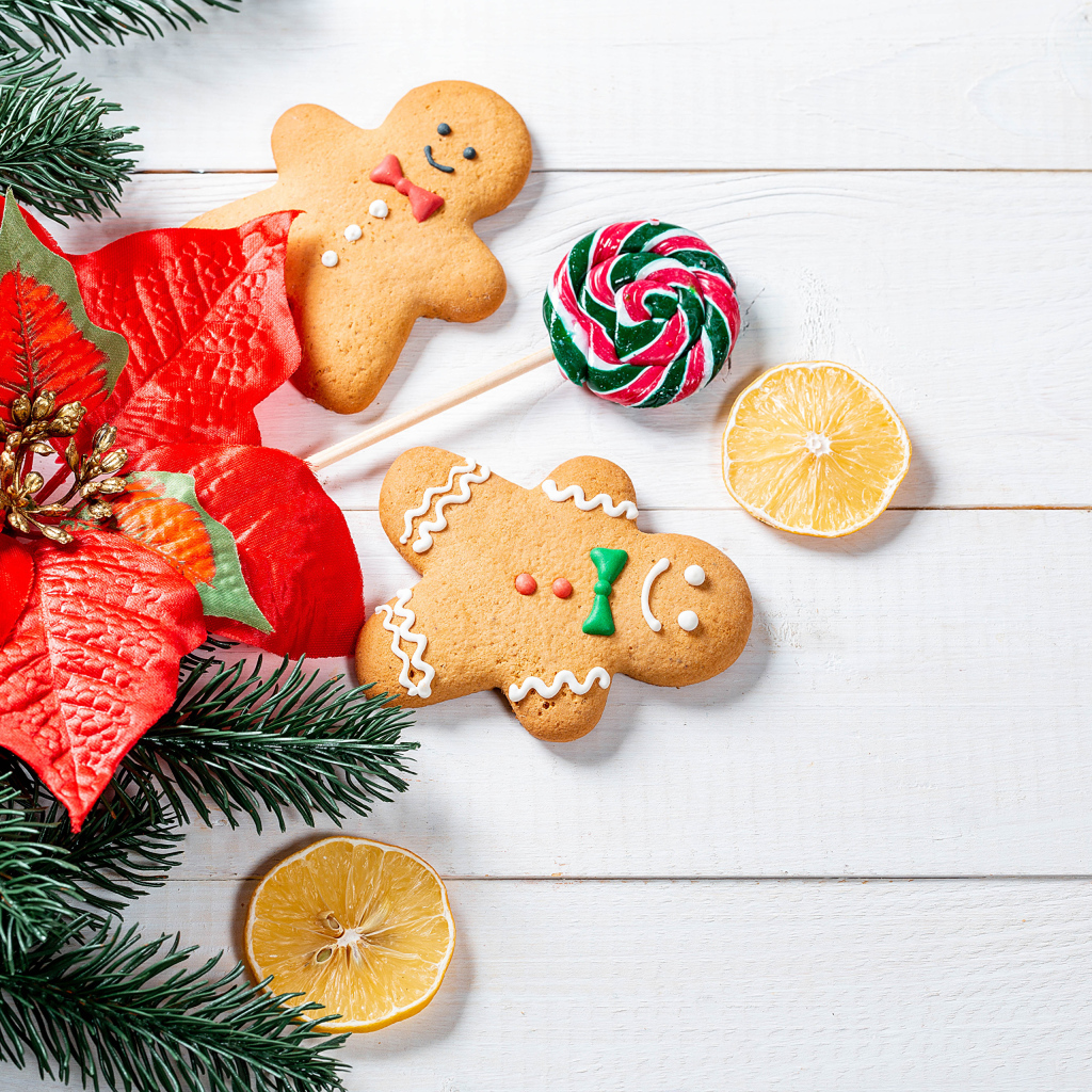 Праздничное печенье с леденцом и еловой веткой на столе 