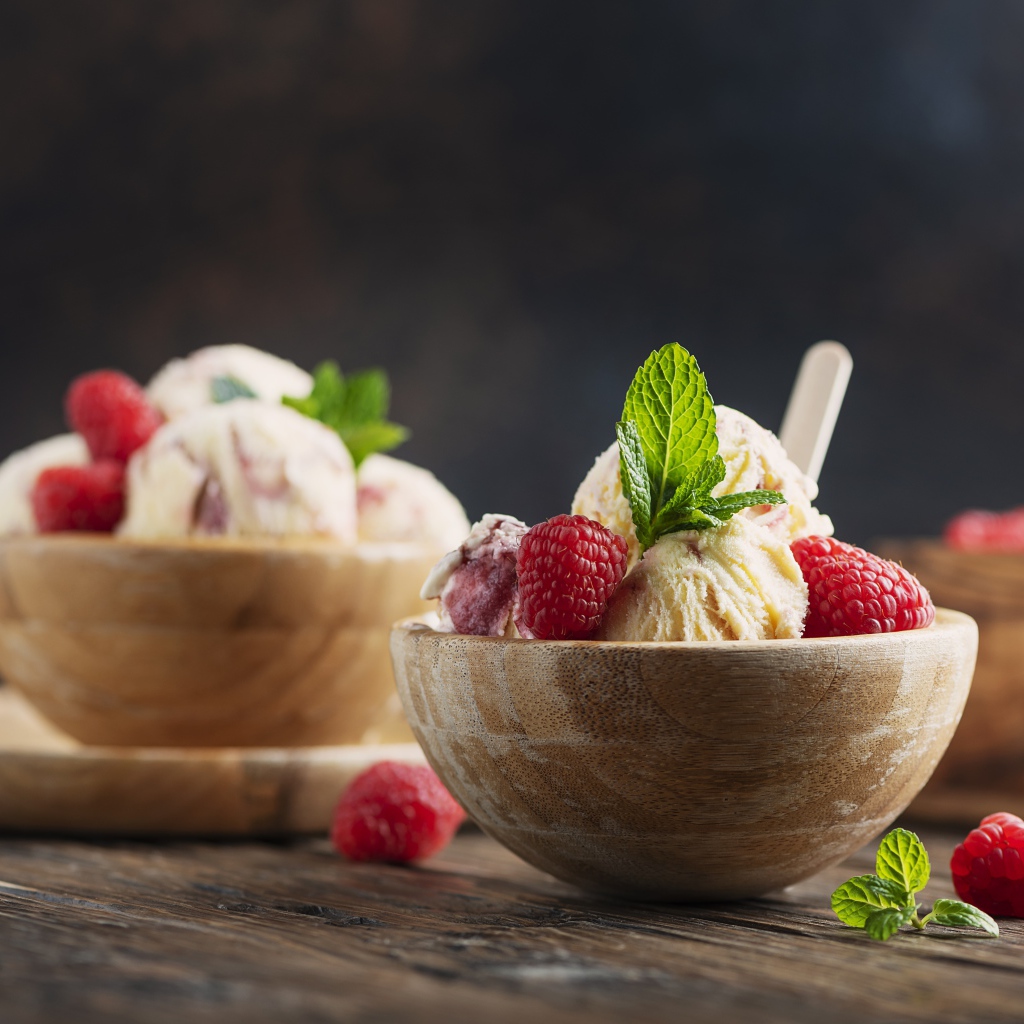 Шарики мороженого в деревянных мисках с ягодами малины