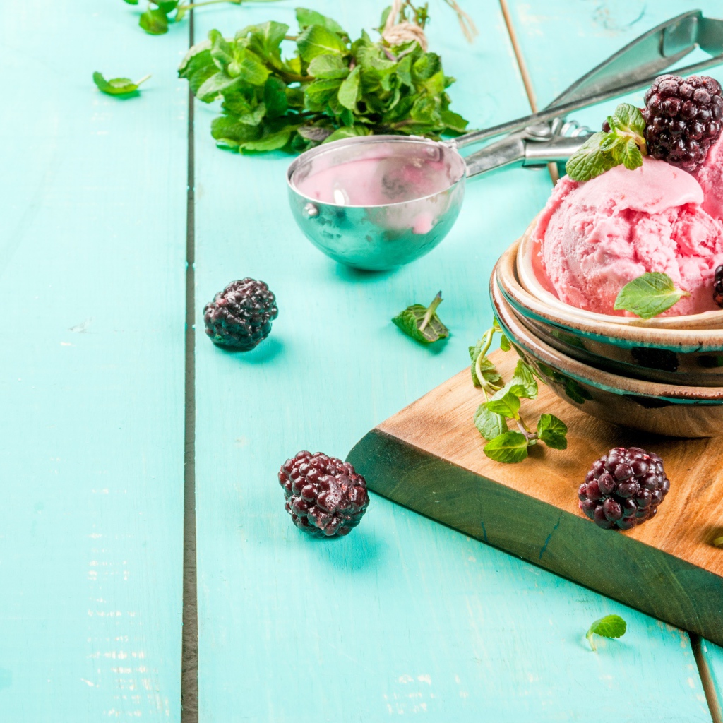 Шарики мороженого на столе с ягодами черники и мятой