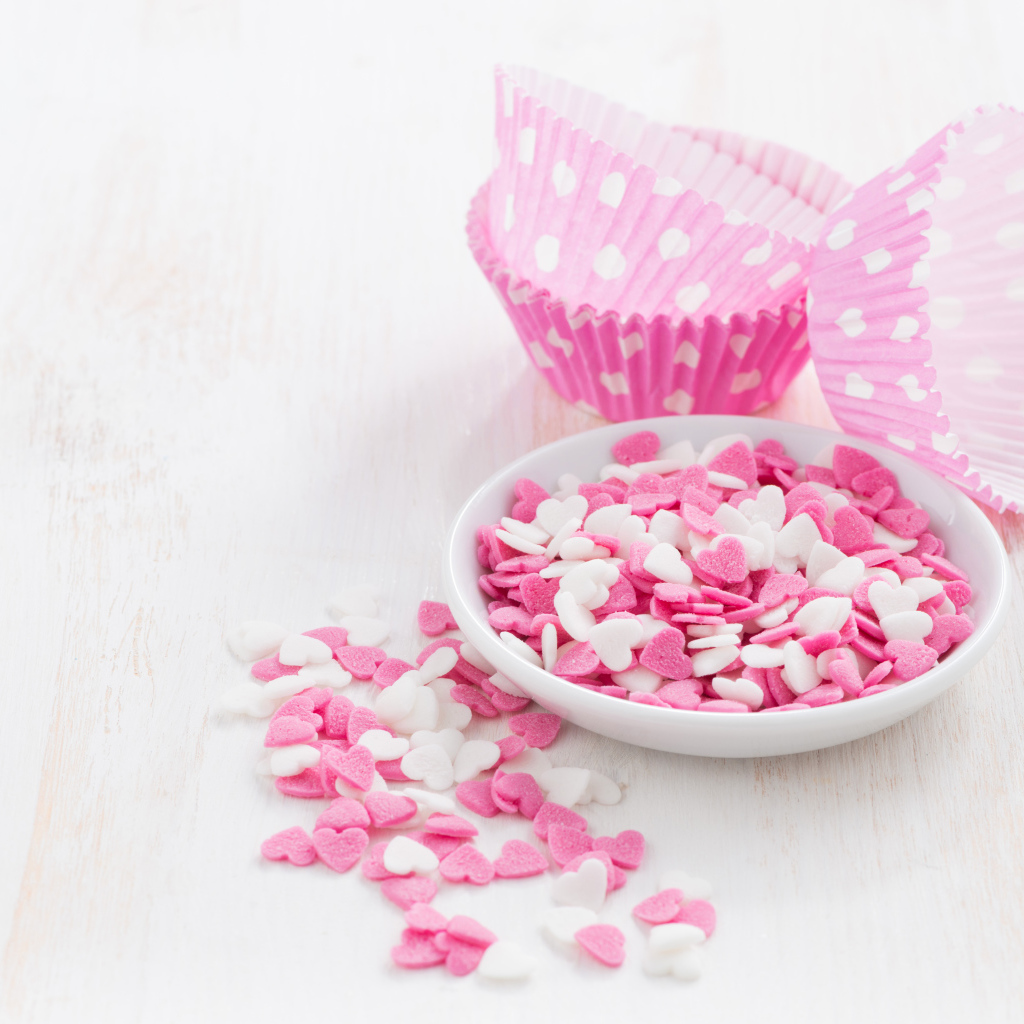 Маленькие белые и розовые сердечки на столе 