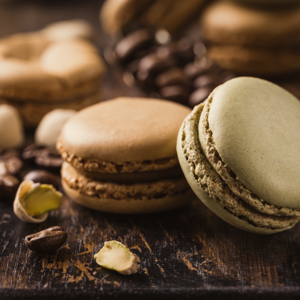 Десерт макарун на столе с кофейными зернами
