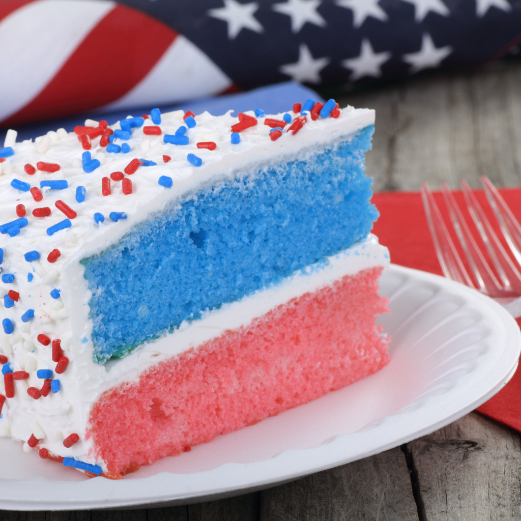 Разноцветный торт на тарелке с кремом