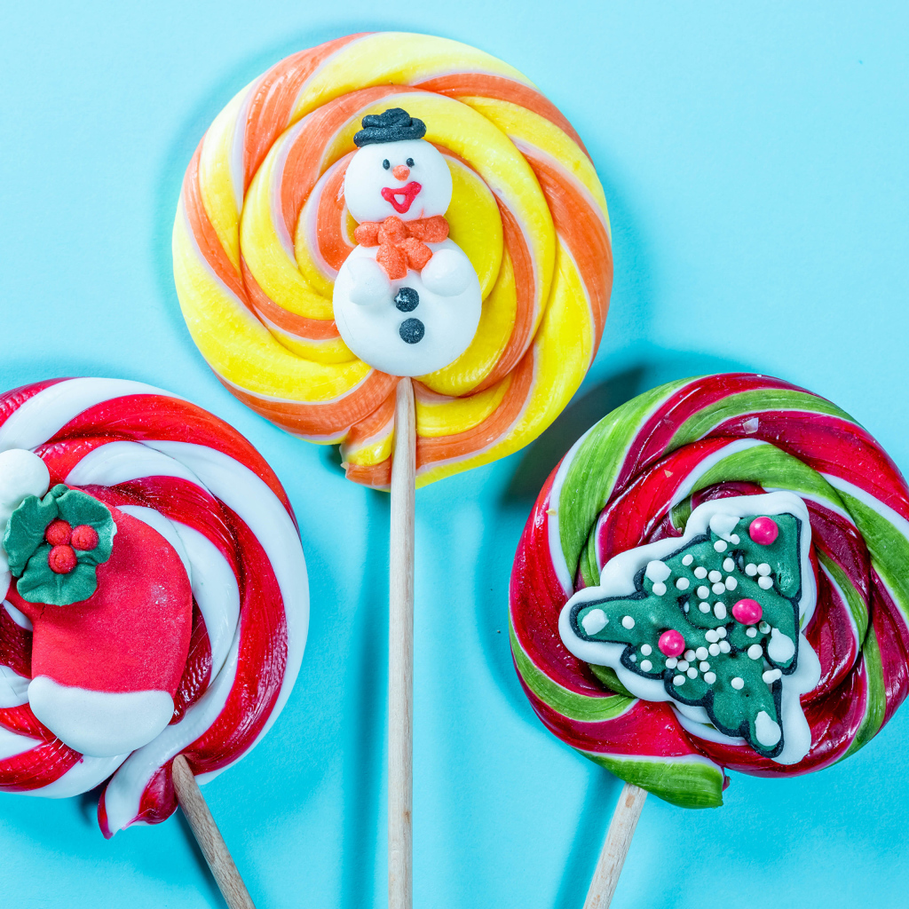 Разноцветные леденцы на палочках на голубом фоне