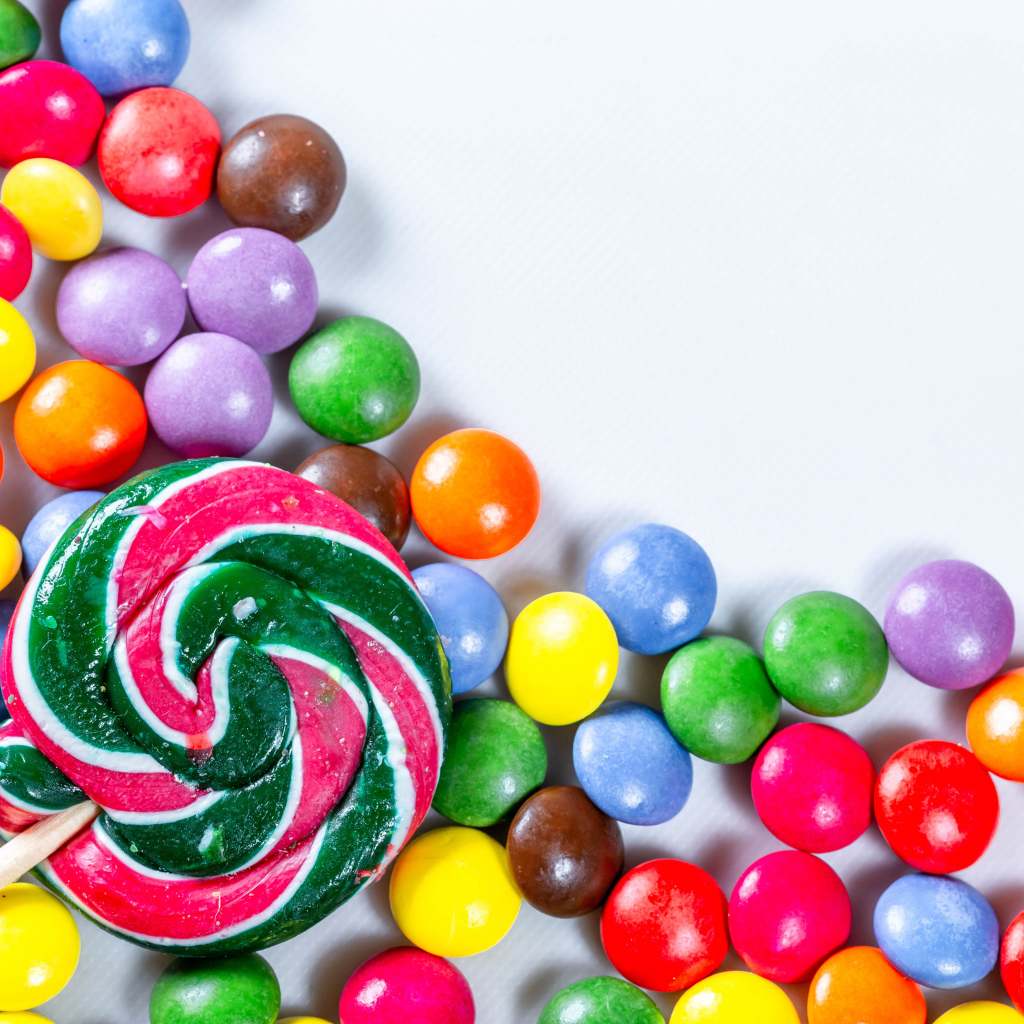 Разноцветные конфеты в глазури и карамель на белом фоне 