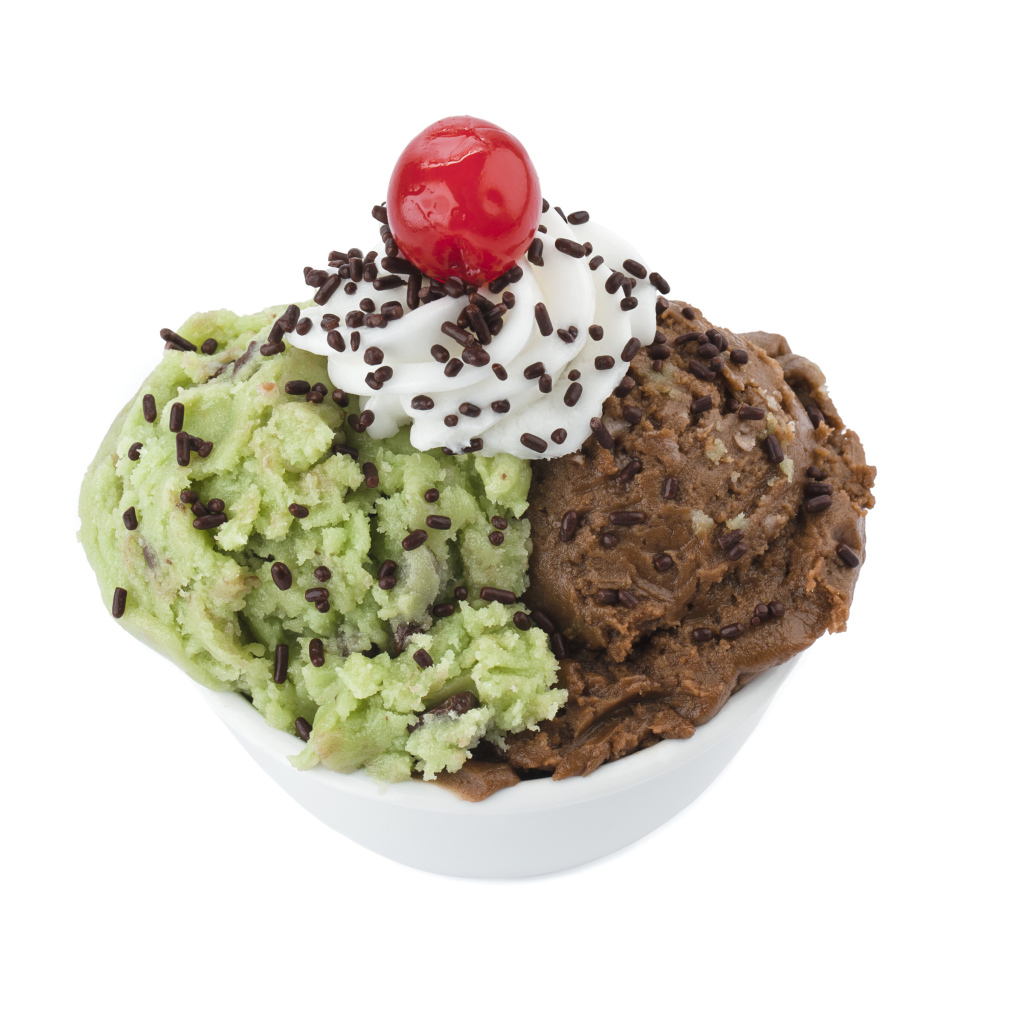 Фисташковое и шоколадное мороженое в креманке на белом фоне