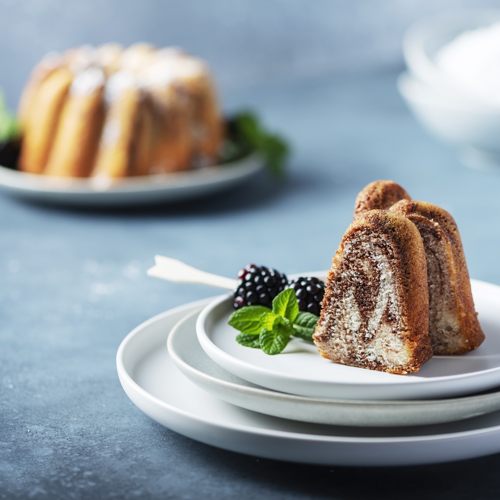 Кусочки кекса на тарелке с ягодами ежевики