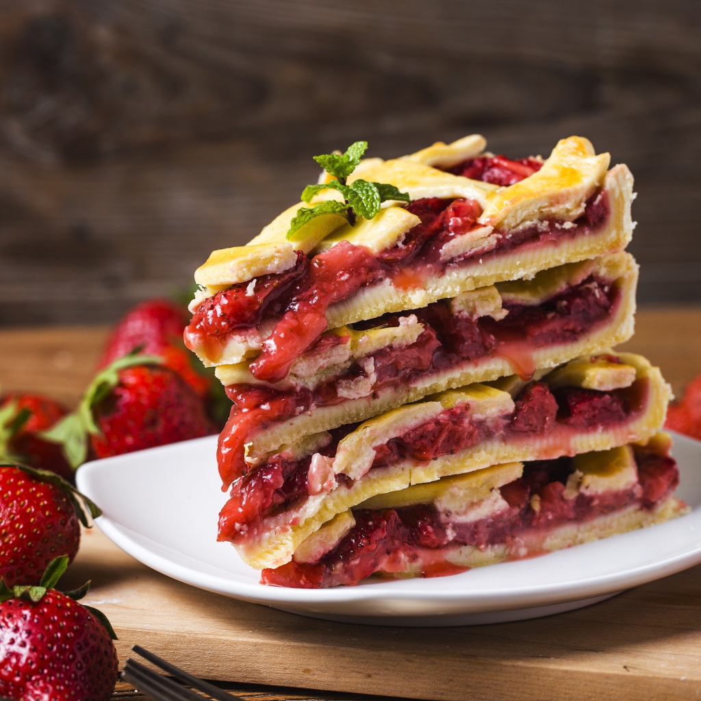 Пирог с ягодами клубники на белой тарелке 