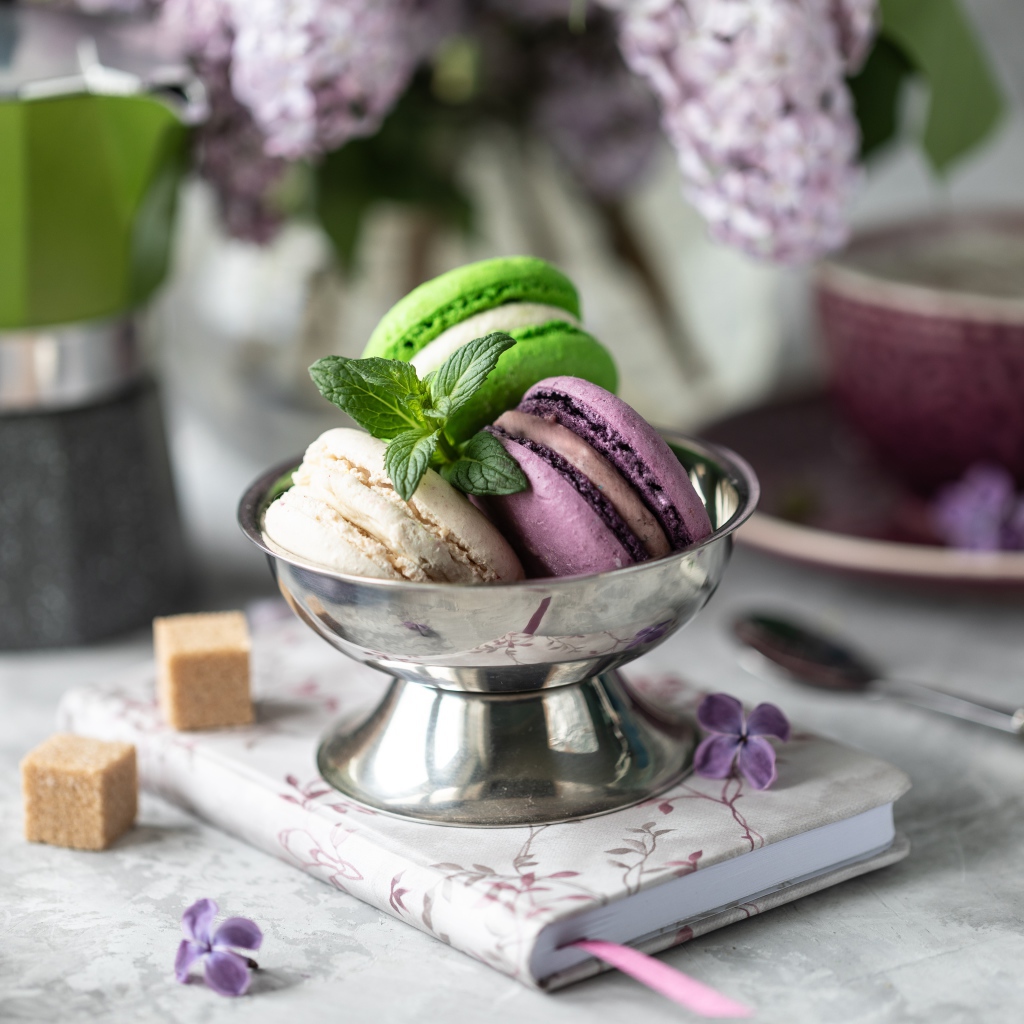 Три печенья макарун на столе с блокнотом