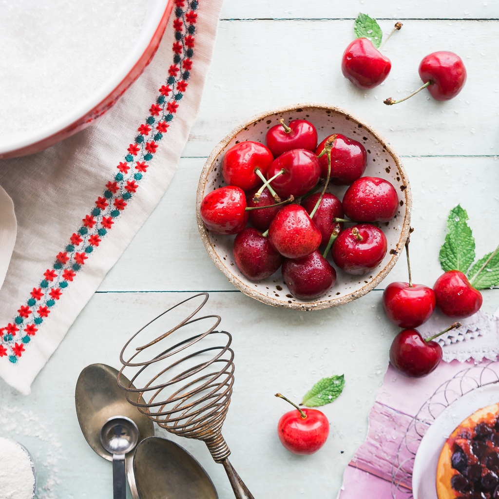 Мокрые ягоды черешни на столе с пирожным