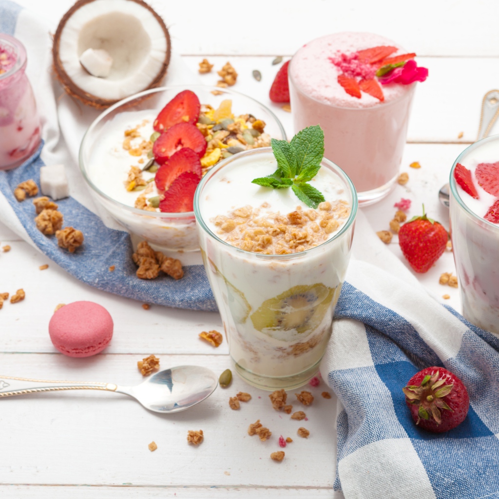 Йогурт с хлопьями и ягодами клубники на столе 