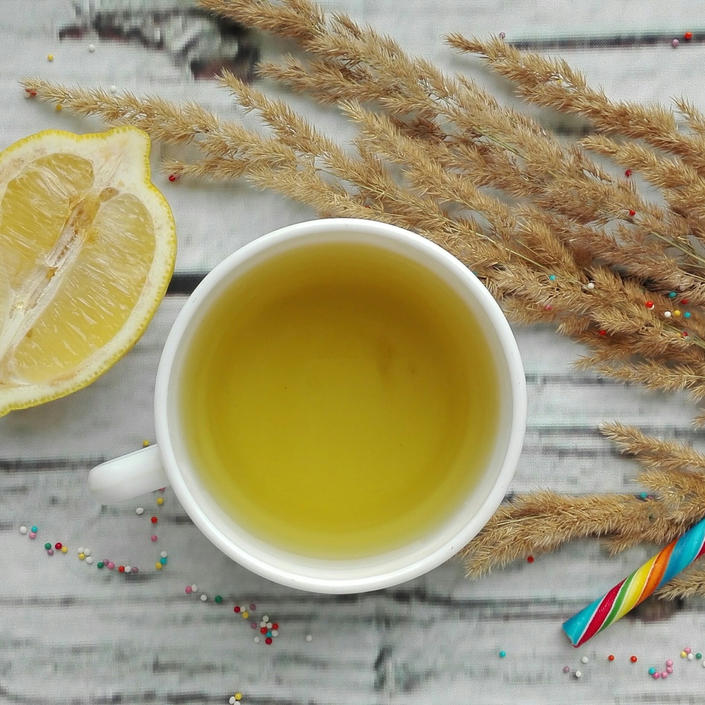 Чашка чая на столе с лимоном и колосьями