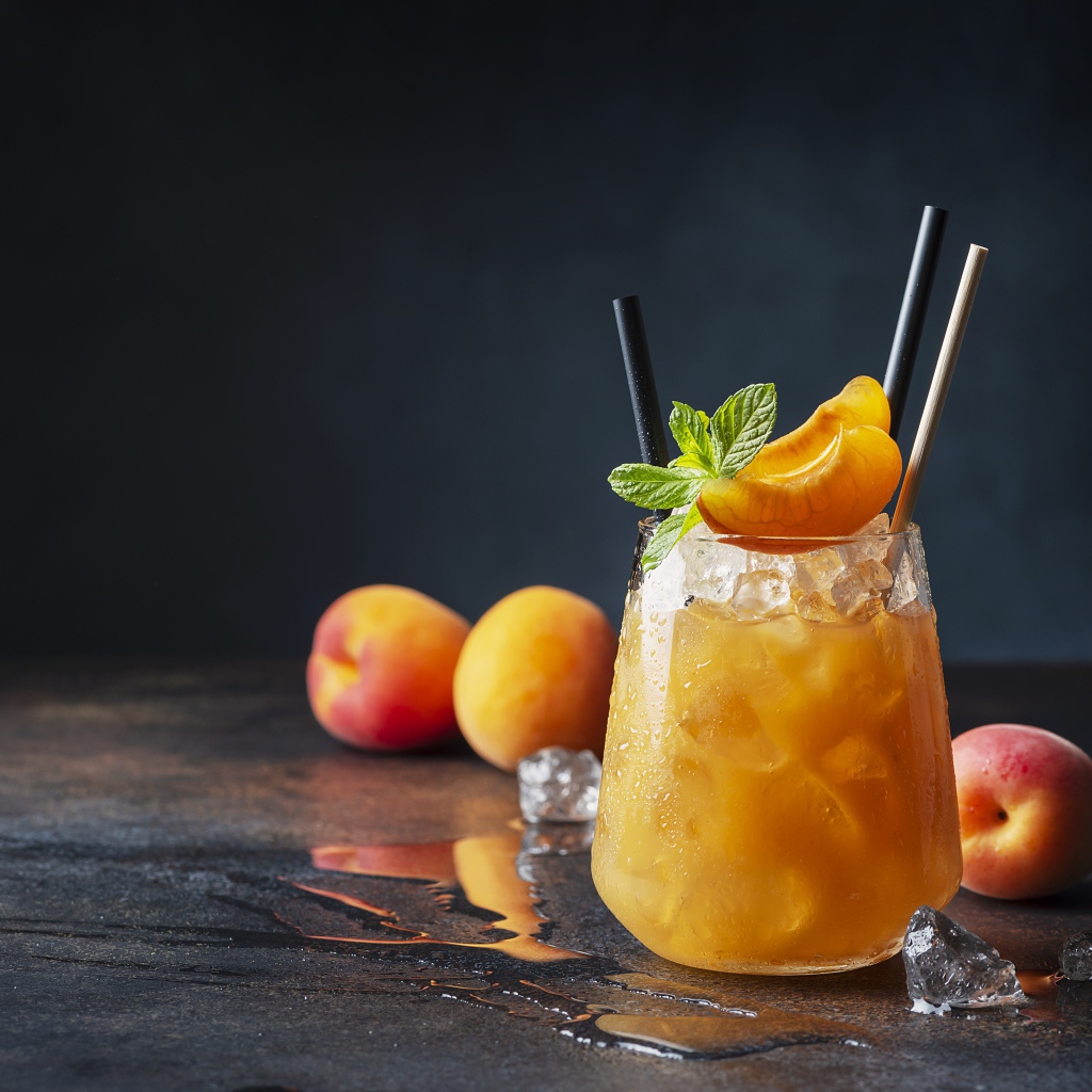 Стакан абрикосового сока со льдом в стакане 