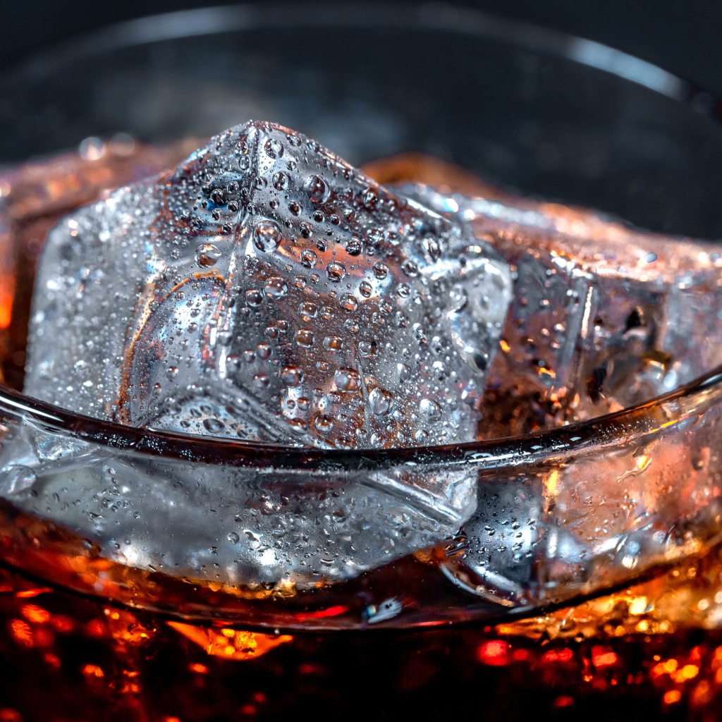 Coca cola drink in a glass with ice cubes