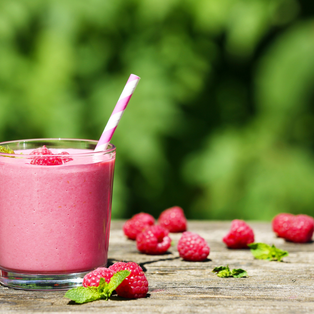 Коктейль в стакане с трубочкой и ягодами малины