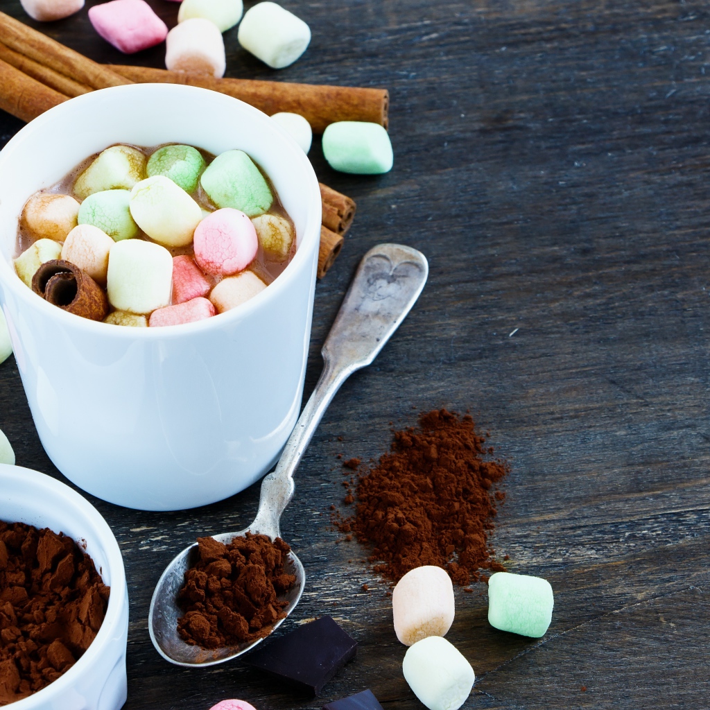 Кофе с маршмеллоу на столе с корицей и сахаром