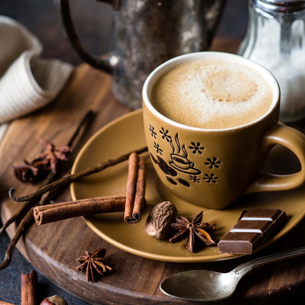 Чашка капучино на блюдце со специями