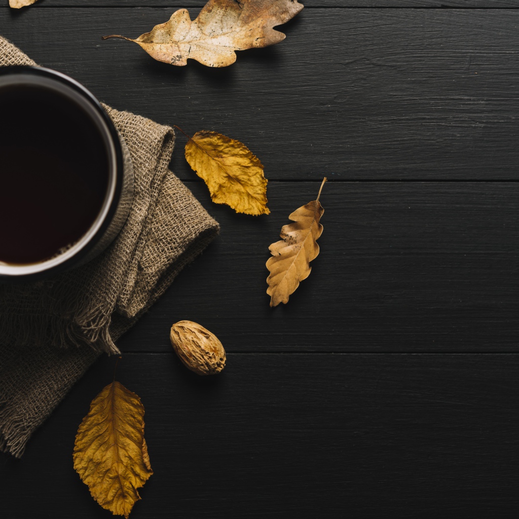 Чашка кофе на черном столе с листьями