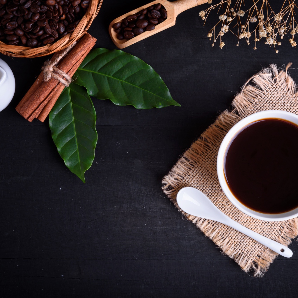 Чашка кофе на столе с корицей и лавровым листом