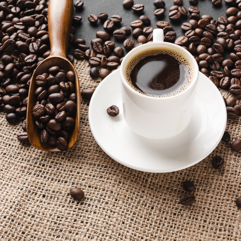 Чашка кофе на столе с зернами 