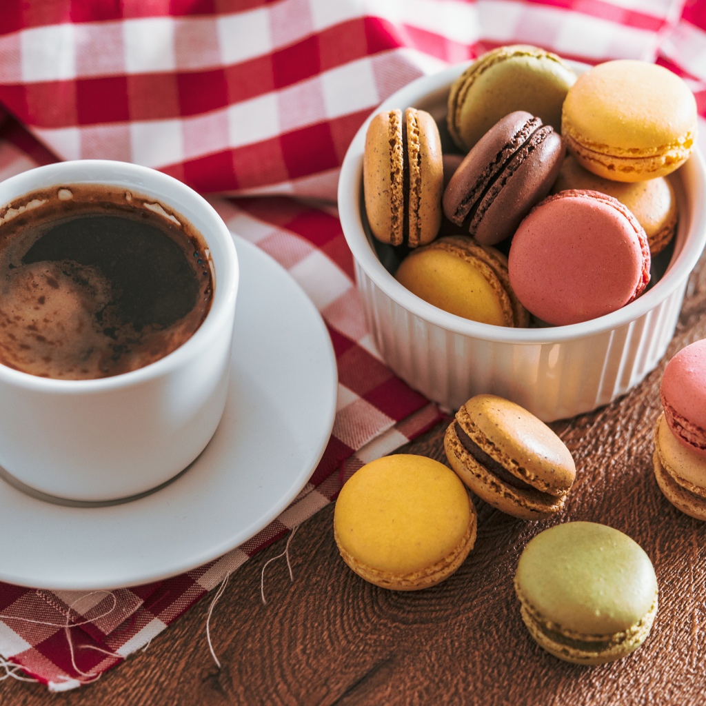 Чашка кофе на столе с десертом макарун 