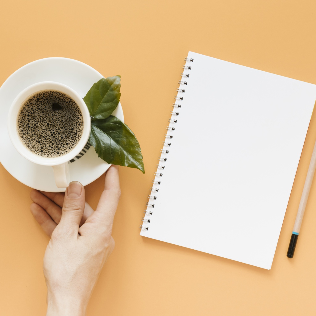 Чашка кофе на столе с блокнотом