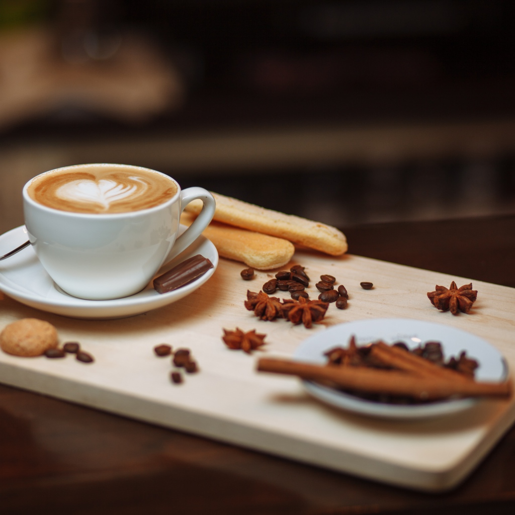 Чашка кофе на столе со специями и печеньем