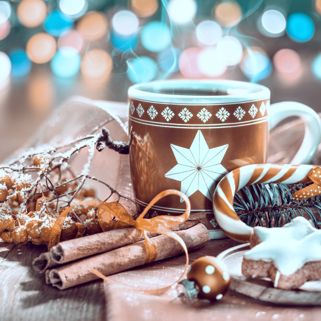 Чашка горячего кофе на столе с корицей и печеньем и веткой рябины