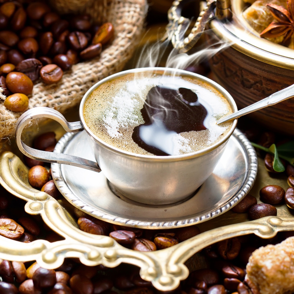 Чашка горячего вкусного кофе на столе с зернами