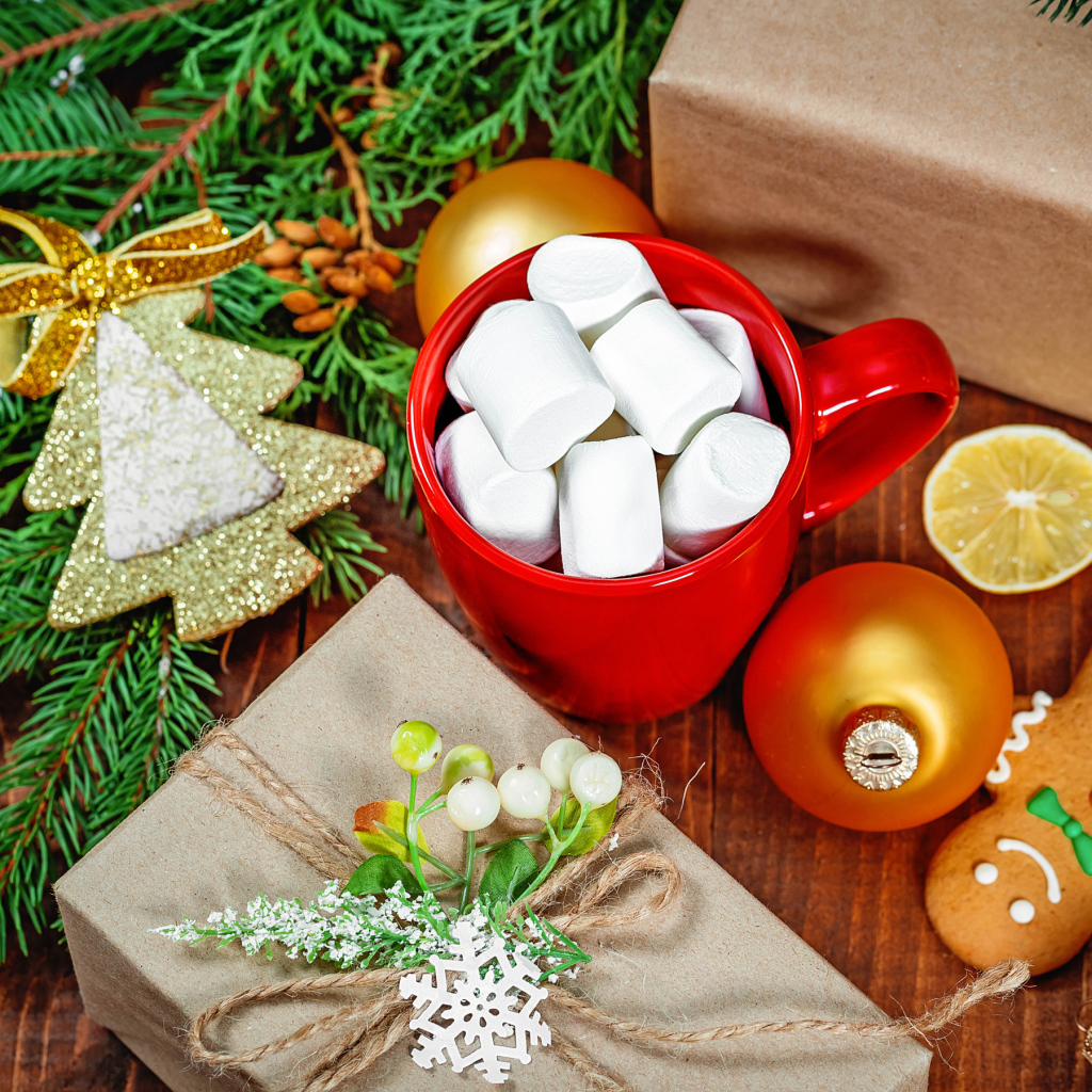 Чашка с маршмеллоу на столе с подарком, печеньем и еловой веткой