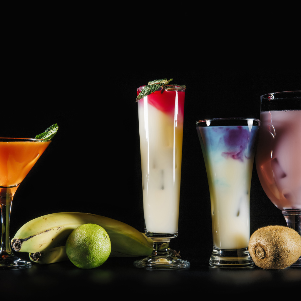 Вкусные тропические коктейли на черном фоне с фруктами