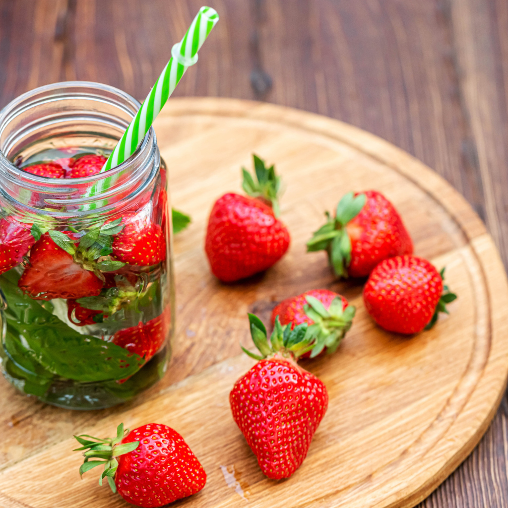 Напиток  в банке с ягодами клубники и трубочкой