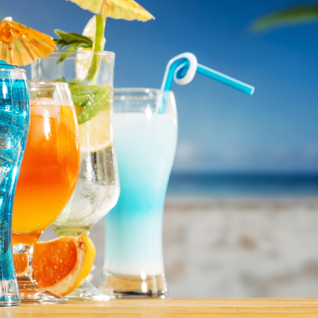 Четыре коктейля стоят на столе пляже 