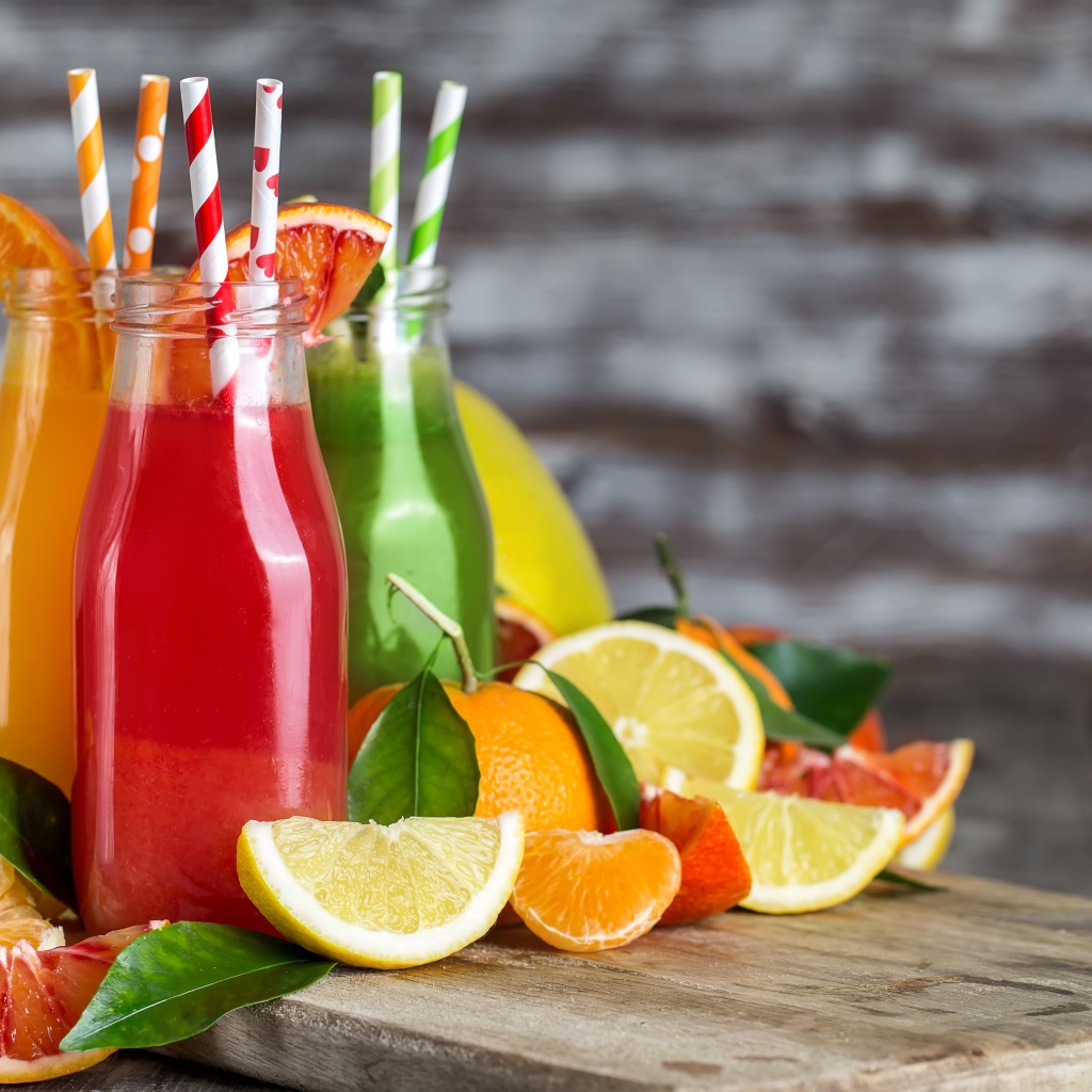Фруктовое смузи на столе в бутылках с трубочками