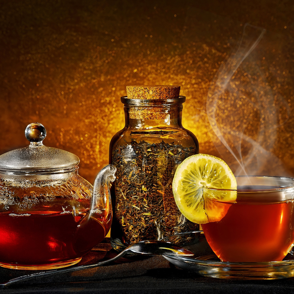 Стеклянный чайник с чашкой на столе с заваркой 