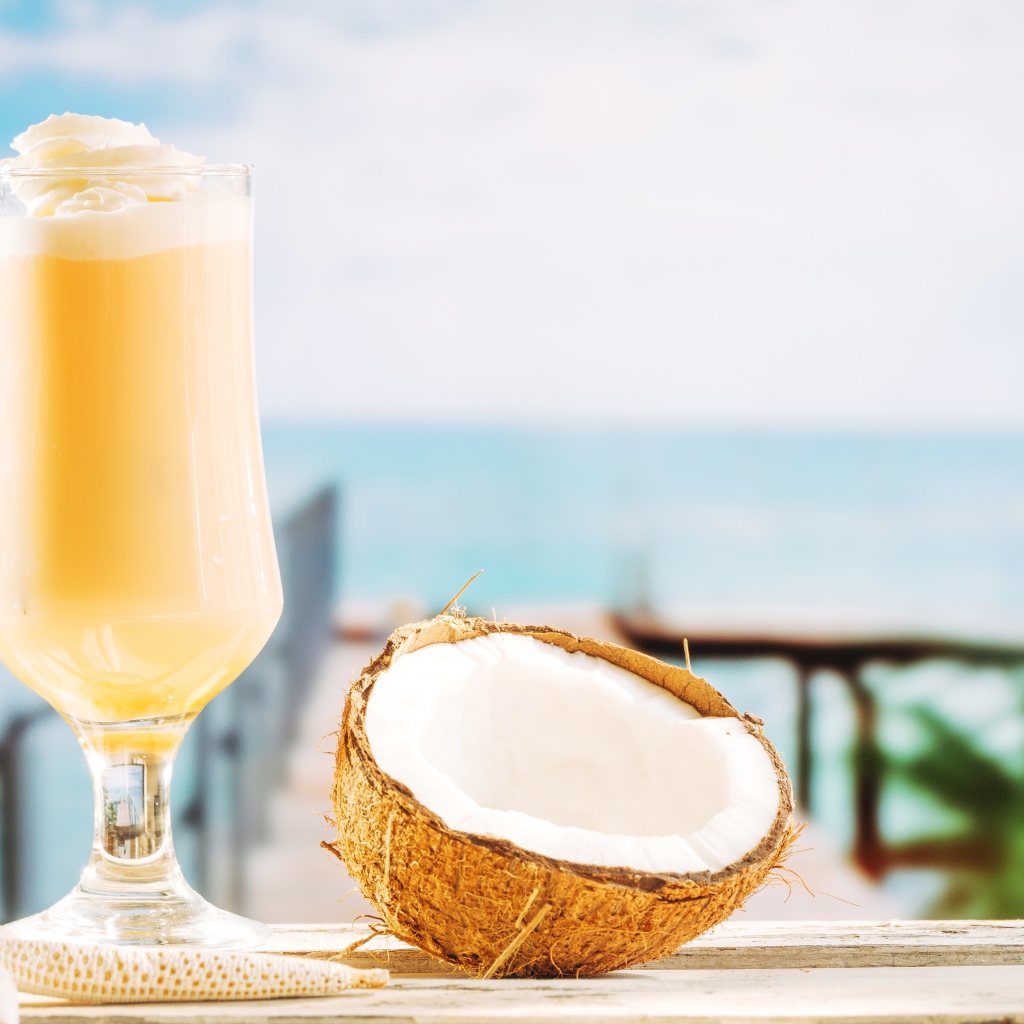 Стакан с коктейлем на столе с кокосом 