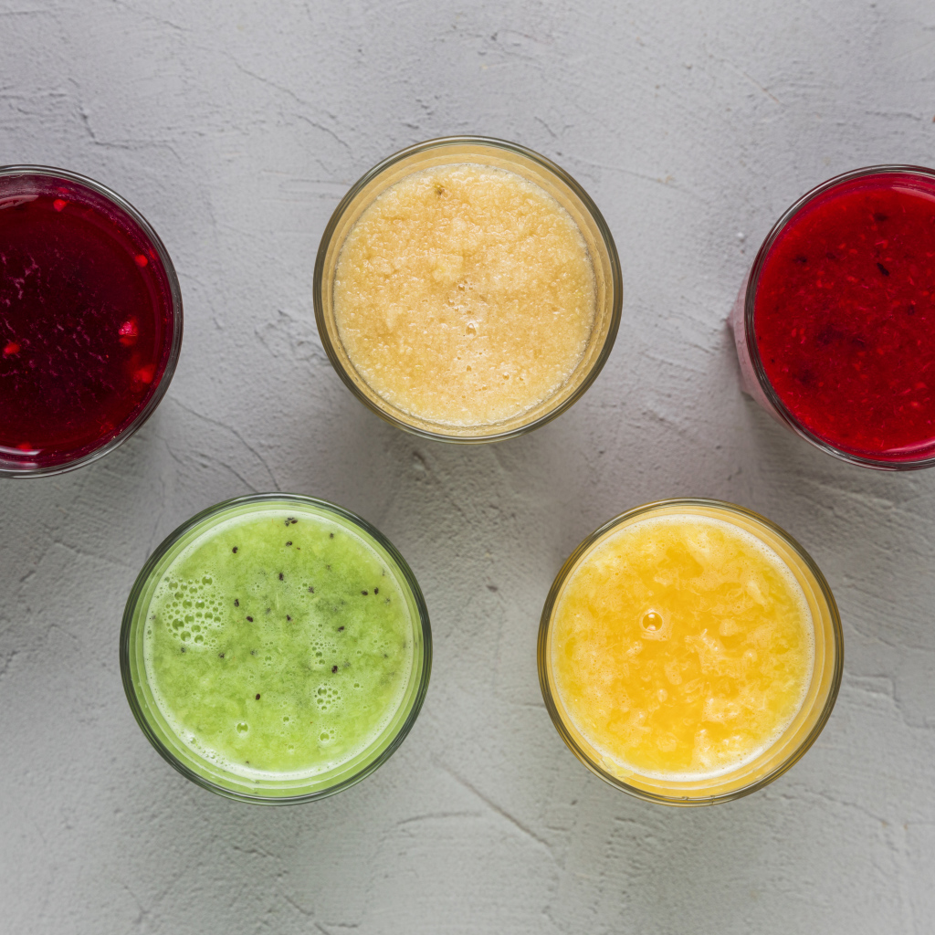 Стаканы с вкусным смузи на сером фоне