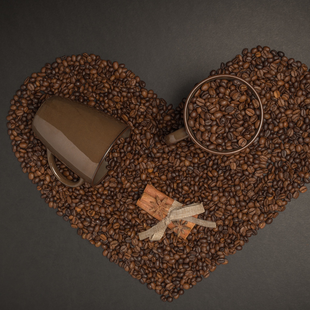 Сердце из кофейных зерен на сером фоне с кружками 
