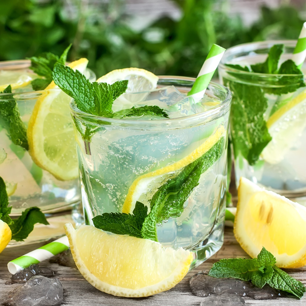 Лимонад с мятой и кусочками лимона в стаканах на столе