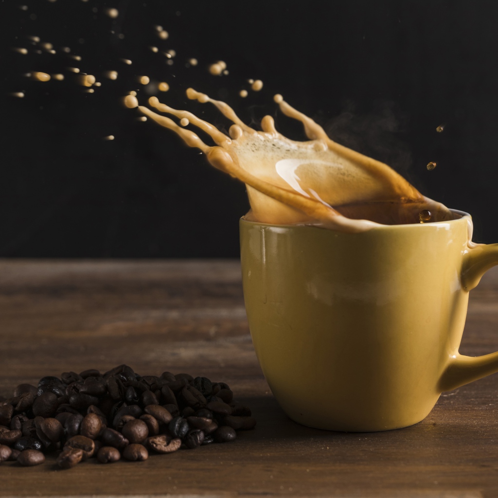 Брызги кофе на столе в чашке 