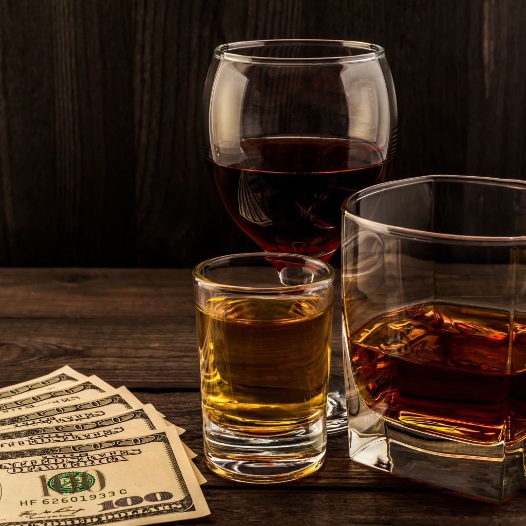 Три сосуда  с виски на столе с долларами