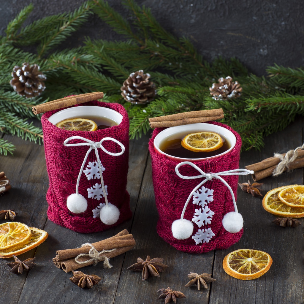 Две чашки горячего чая с лимоном на столе с еловыми ветками