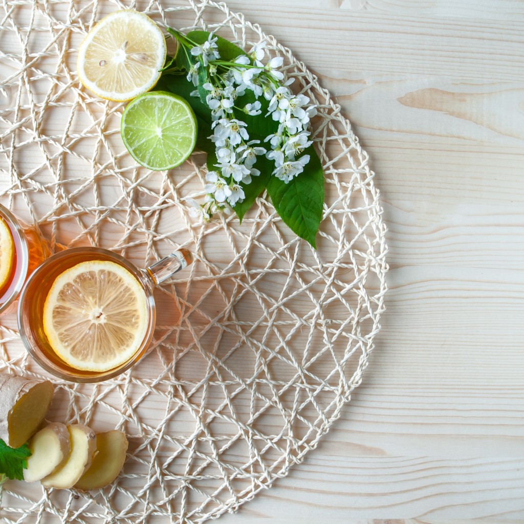 Две чашки чая с лимоном на плетеной подставке 