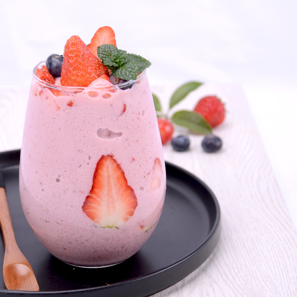 Йогурт в стакане с ягодами черники и клубники