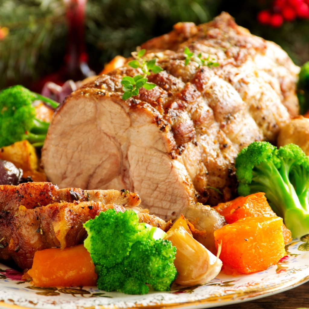 Кусок запеченного мяса на тарелке с овощами