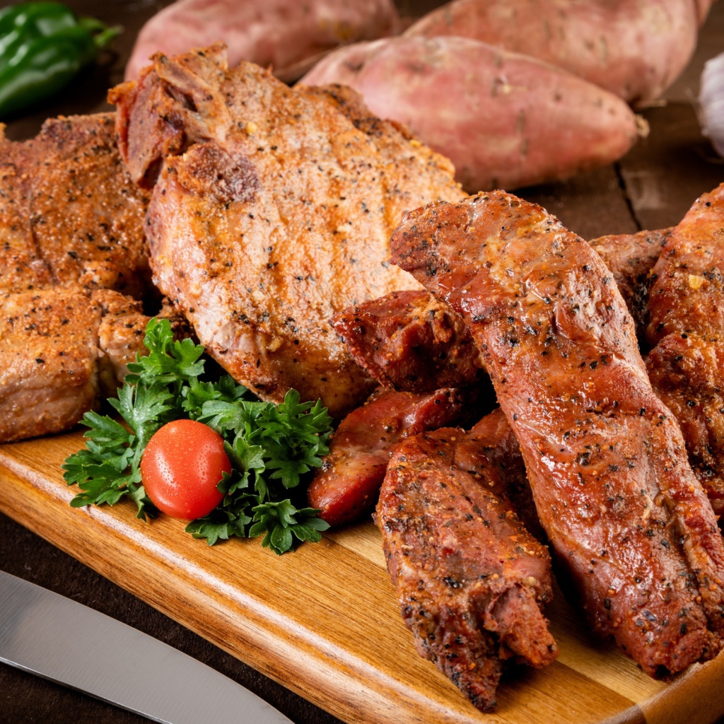 Аппетитное запеченное мясо на столе с чесноком и картофелем