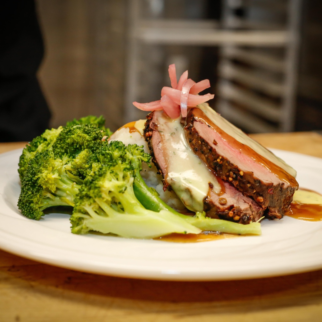 Брокколи на тарелке с кусочками запеченного мяса 