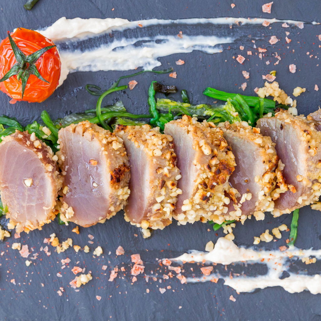 Вяленое мясо на столе с зеленью и помидором 