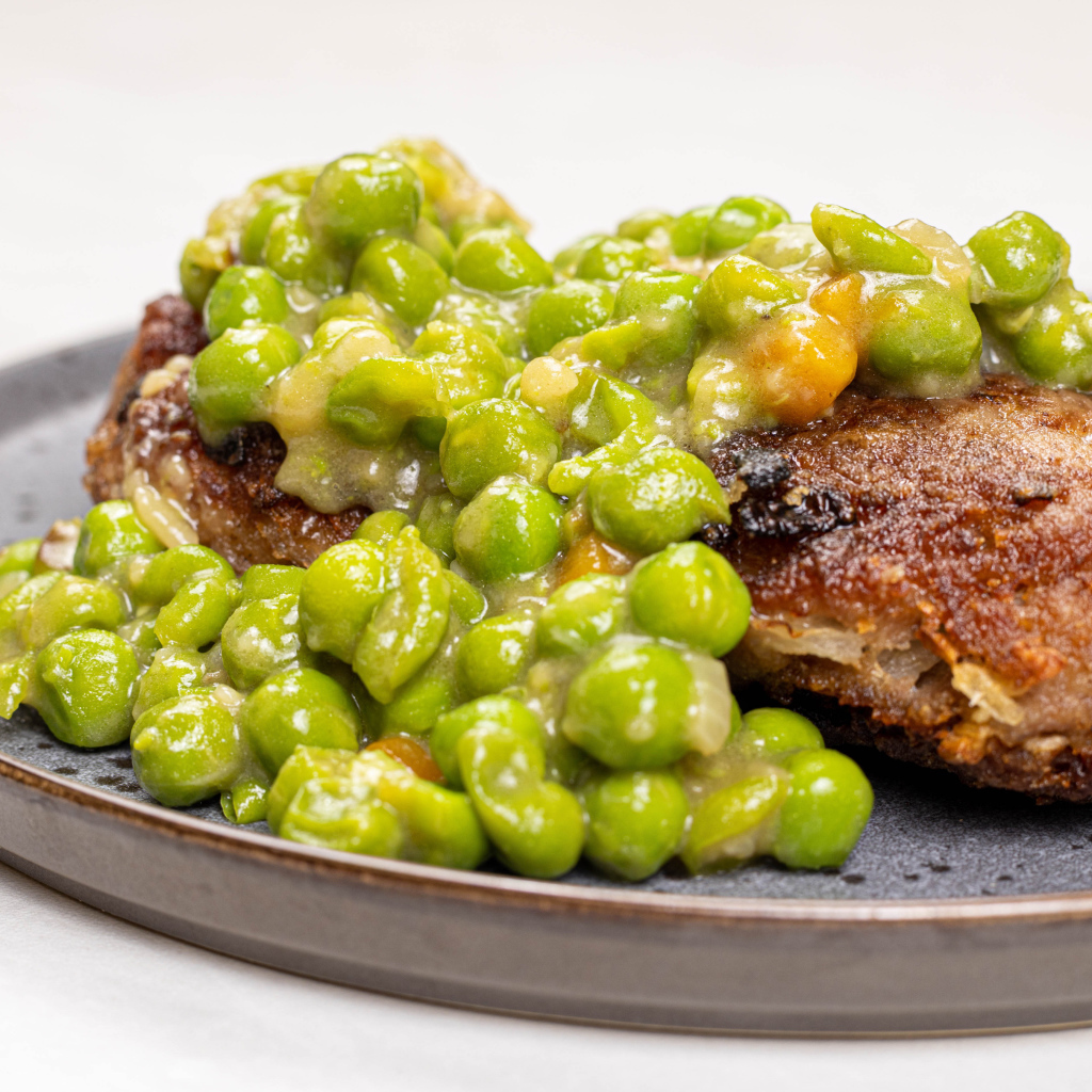 Котлета на тарелке с зеленым горошком