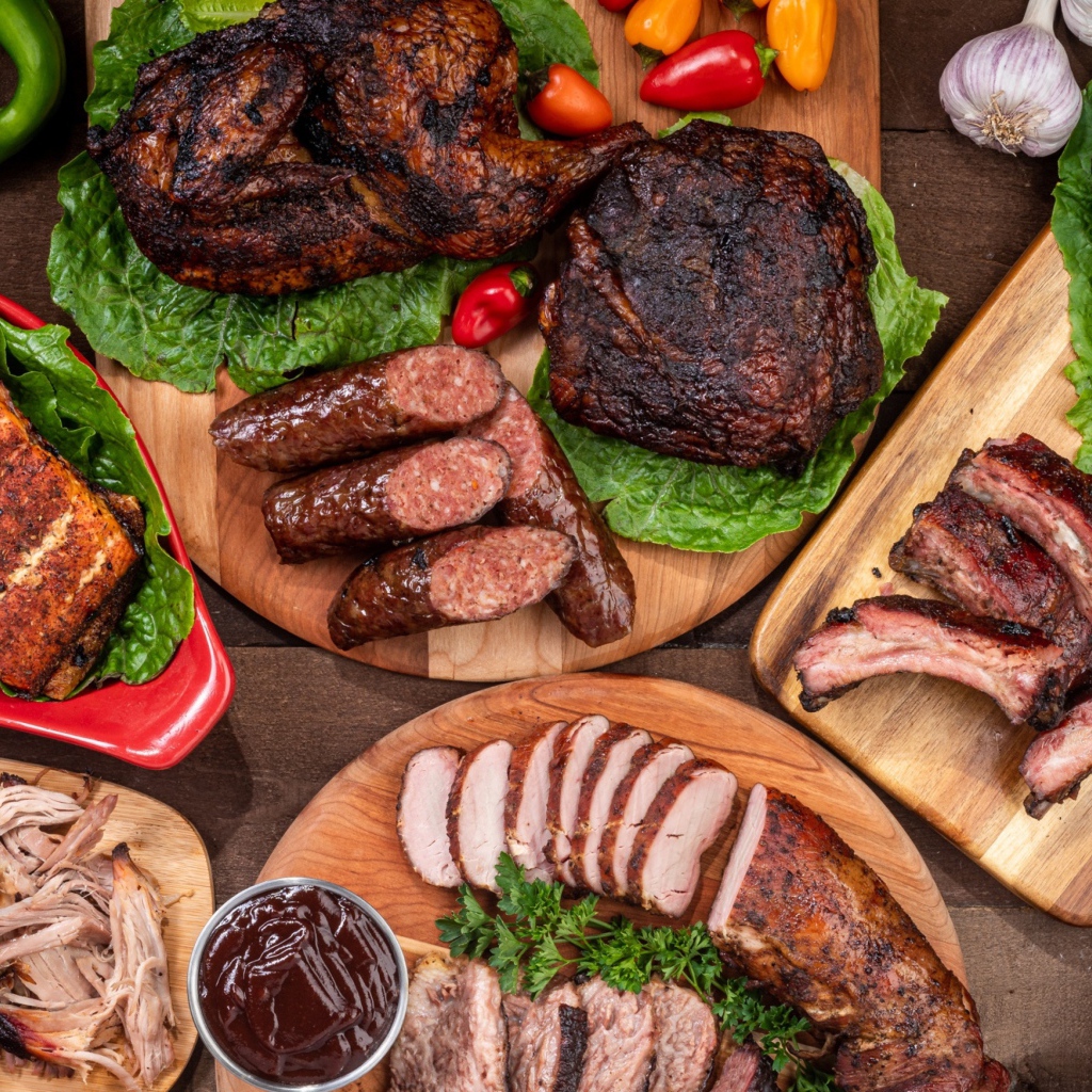 Вкусные запеченные мясные продукты на столе с овощами 